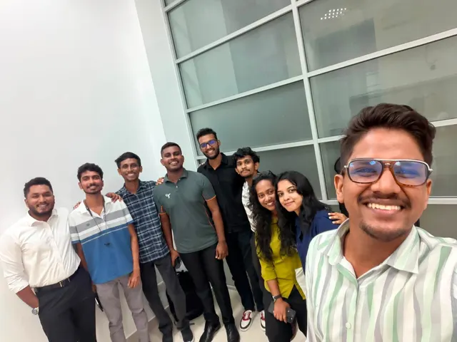 A wide selfie of ten organisers against a glass wall